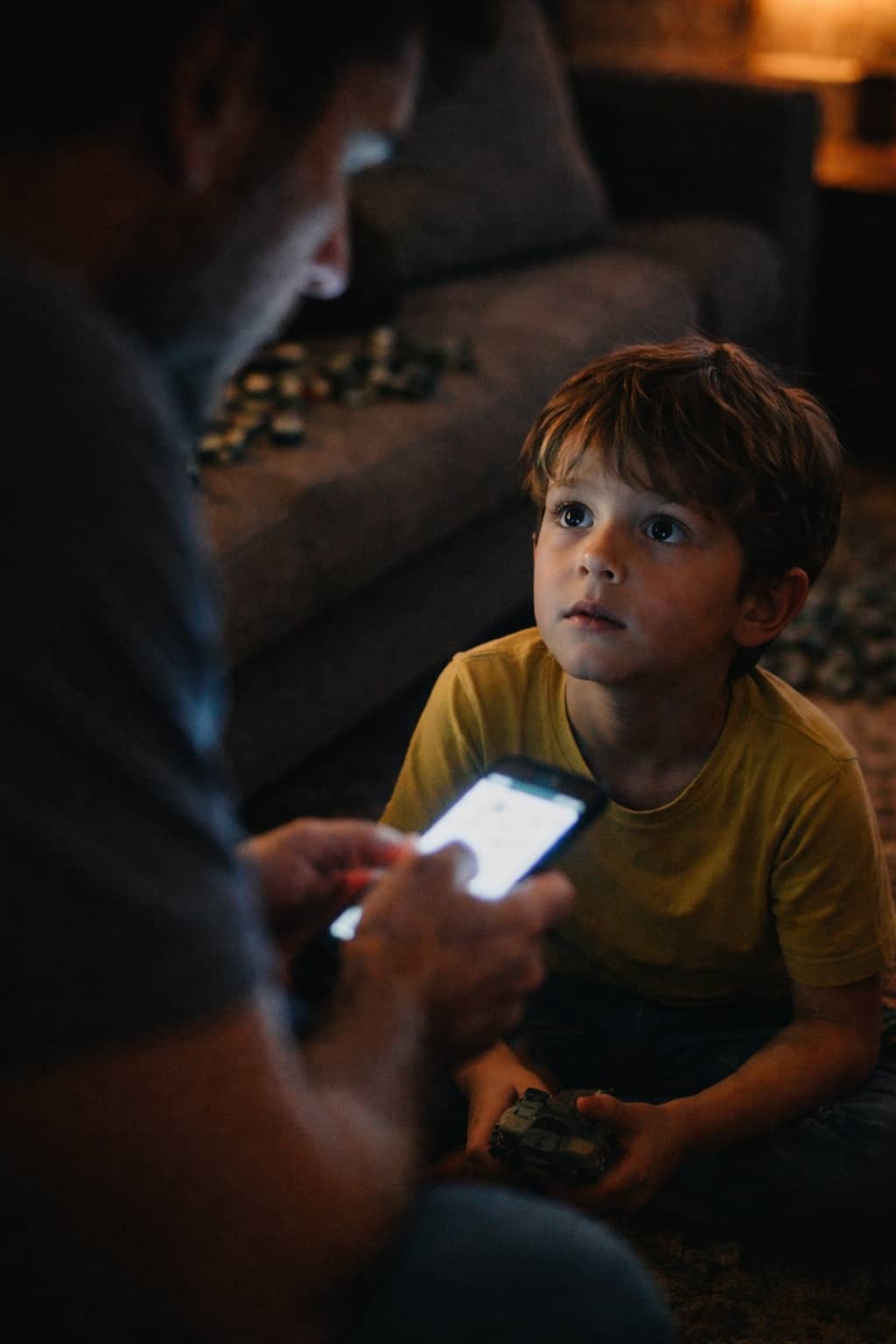 ילד מסתכל על אבא שלו בזמן שאבא שלו שקוע במסך ילד מסתכל על אבא שלו בזמן שאבא שלו שקוע במסך